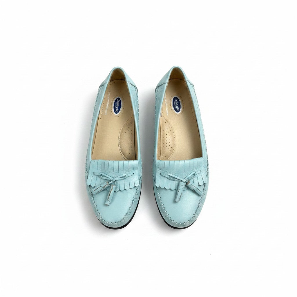 Pair of light blue loafers with tassels on a white background
