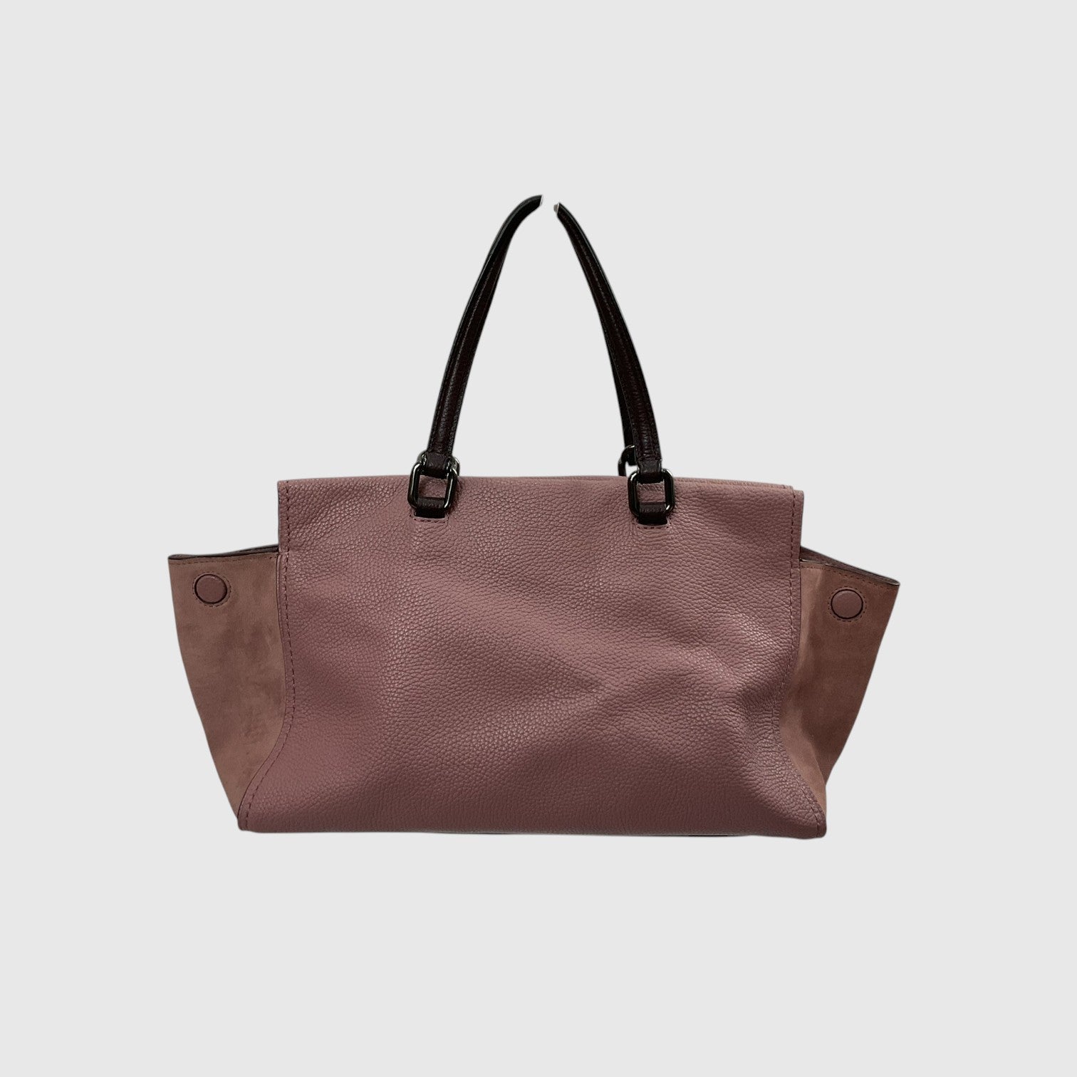 A dusty rose pebbled leather tote bag with black shoulder straps and side pockets, shown against a light gray background.