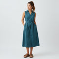 Woman wearing a teal dress on a white background