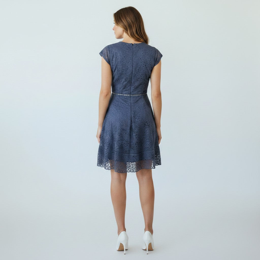 Woman wearing a blue lace dress on a light gray background