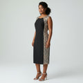 Woman wearing a black dress with a patterned side panel on a white background
