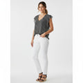 Woman wearing a gray blouse and white pants on a white background