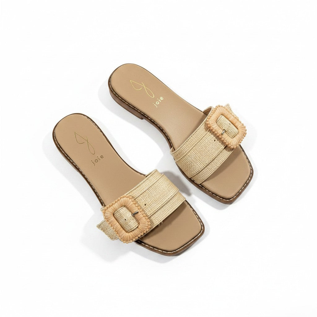 Pair of beige sandals with woven straps on a white background