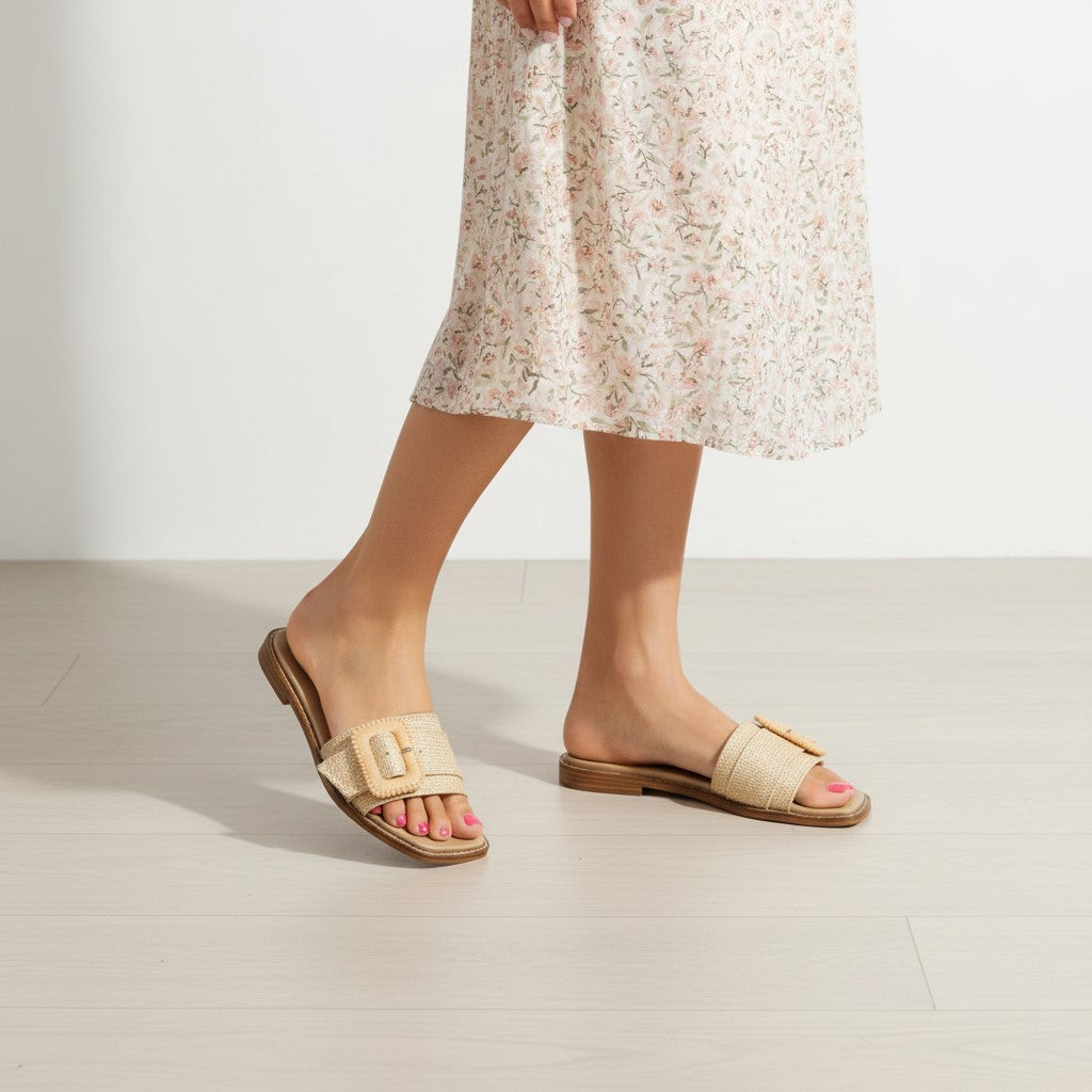 Beige sandals worn with a floral dress on a light background