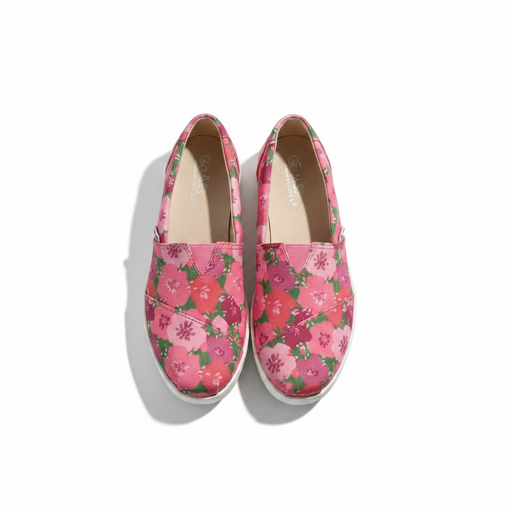 Pair of pink floral slip-on shoes on a white background