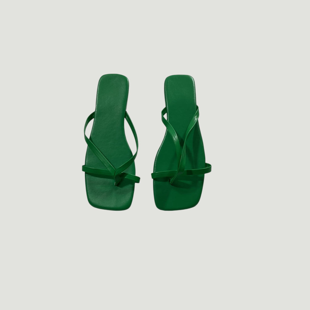 Pair of green sandals on a light gray background