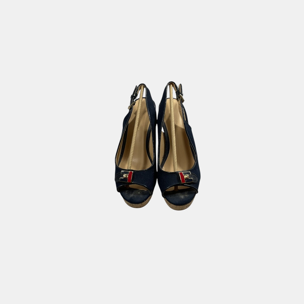 Pair of black high-heeled shoes with gold interior on a white background