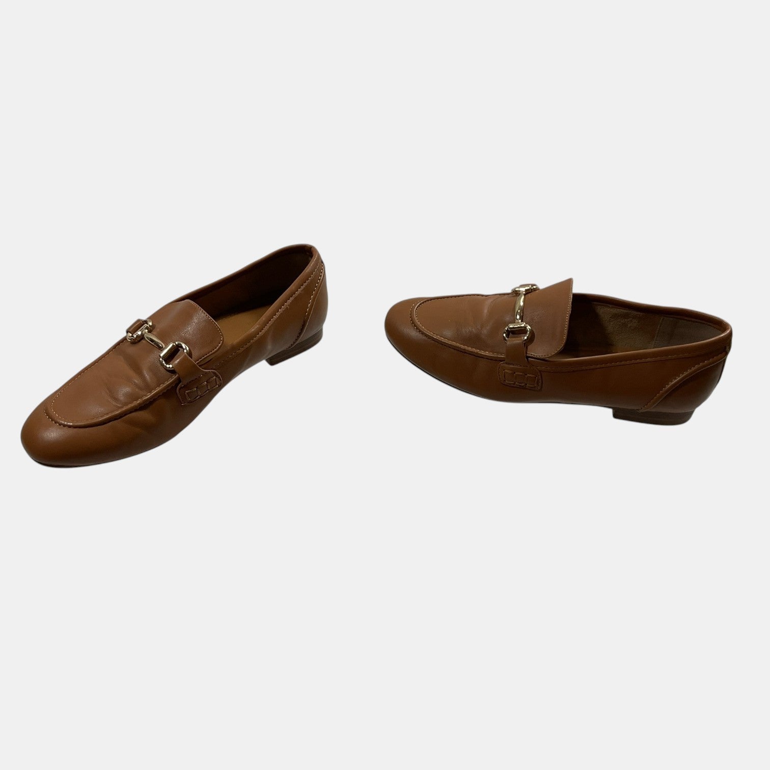 brown leather loafers with a horse bit on a white background