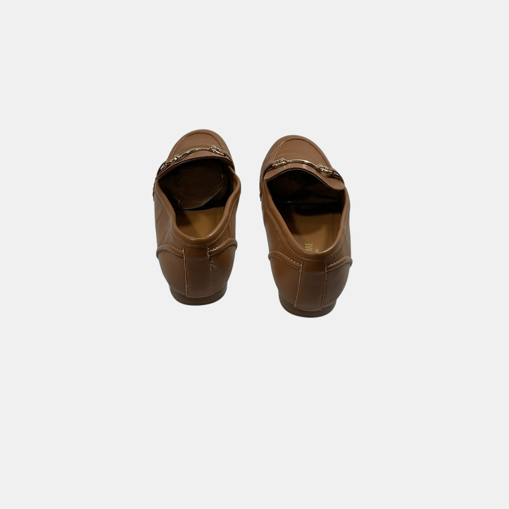 brown leather loafers with a horse bit on a white background