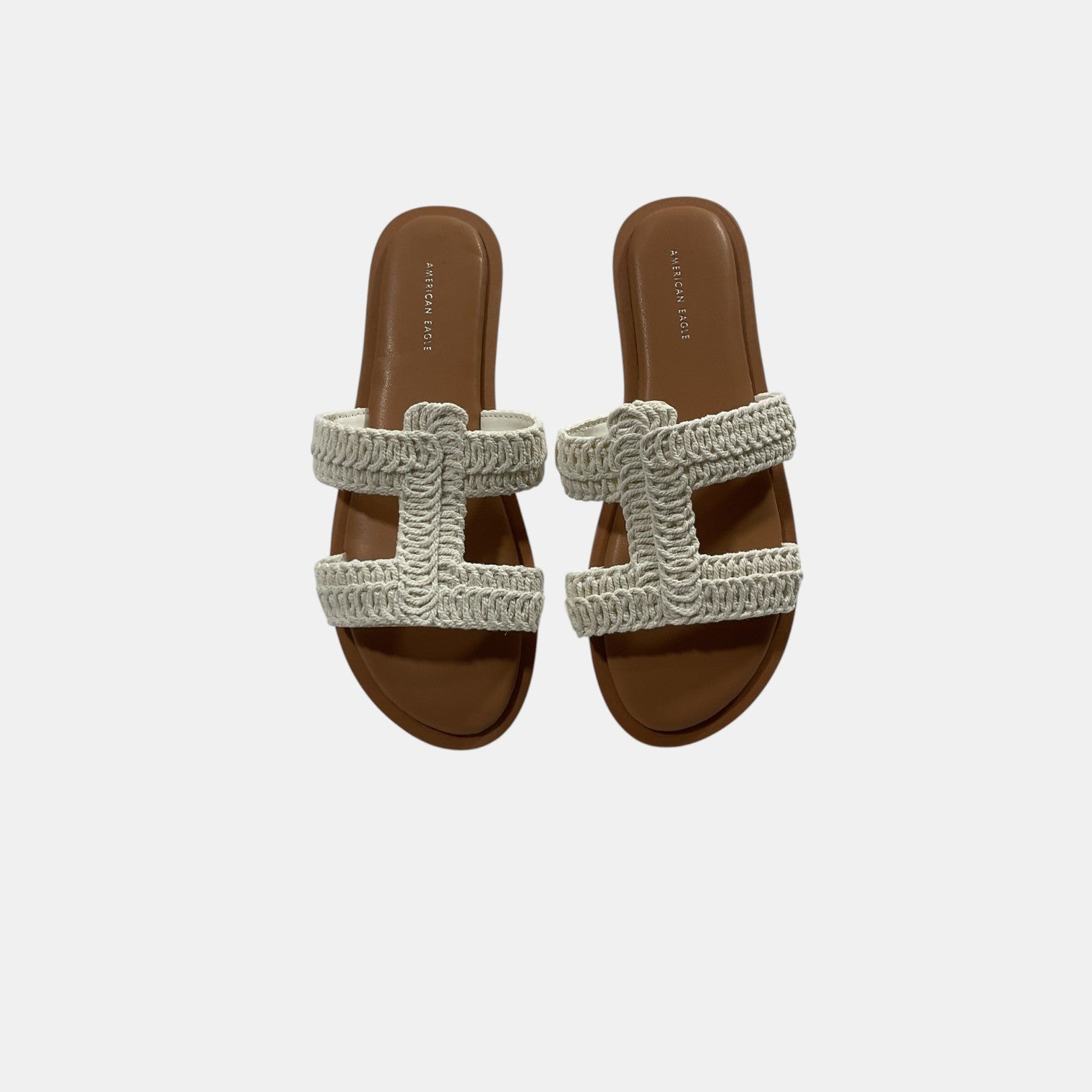 Pair of sandals with woven straps on a light gray background