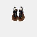 Pair of black sandals with brown soles on a white background