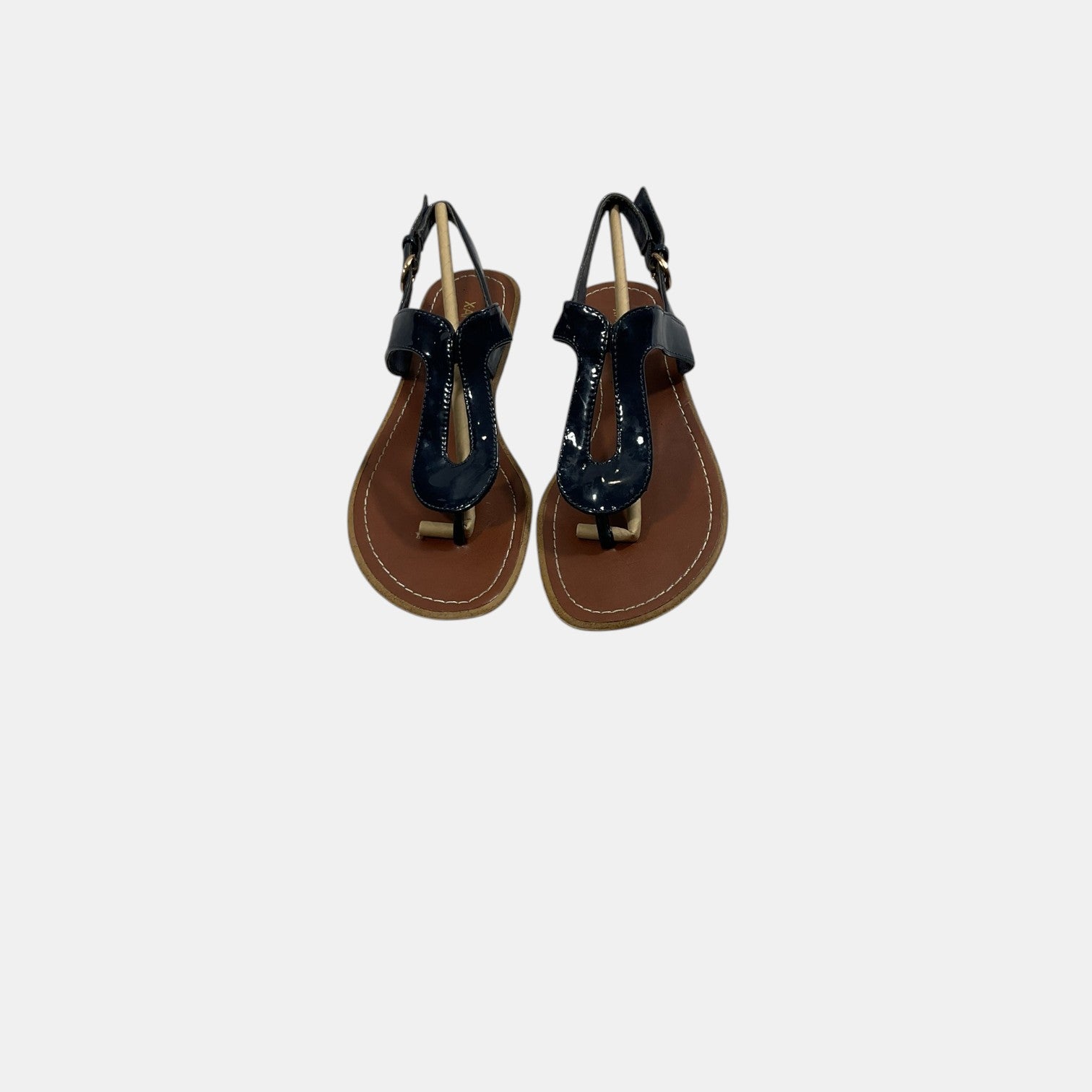 Pair of black sandals with brown soles on a white background