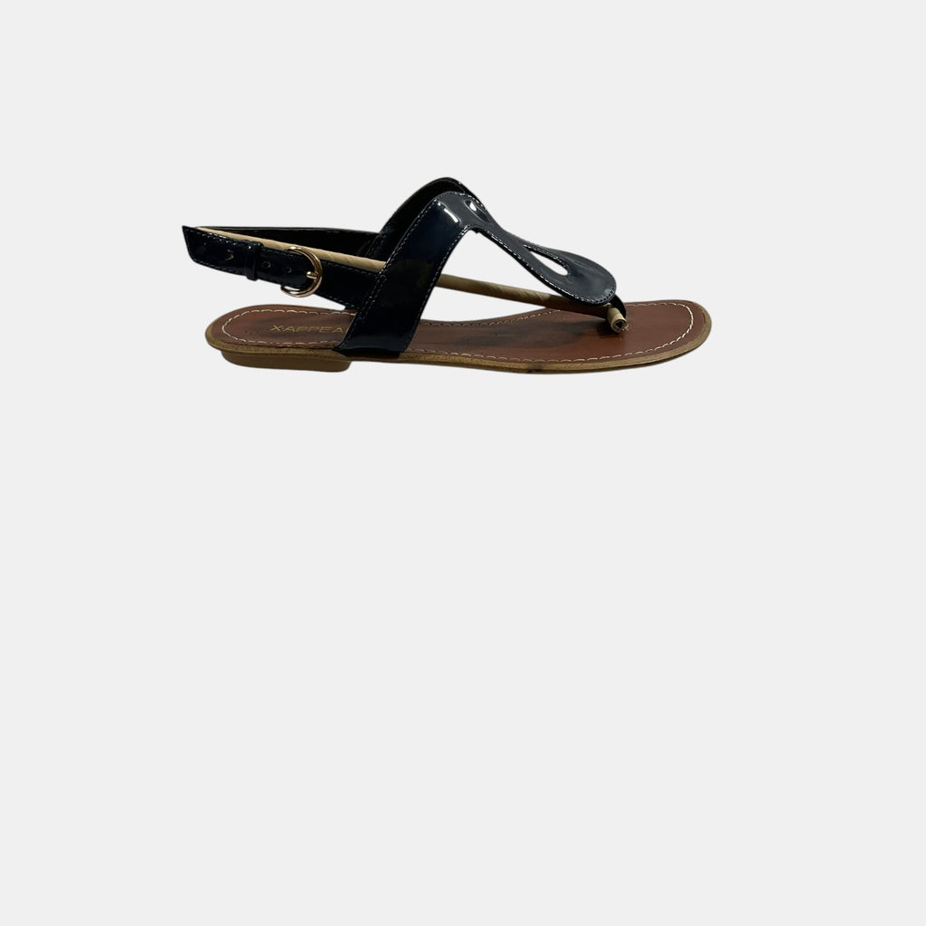 Black sandal with a brown sole on a white background