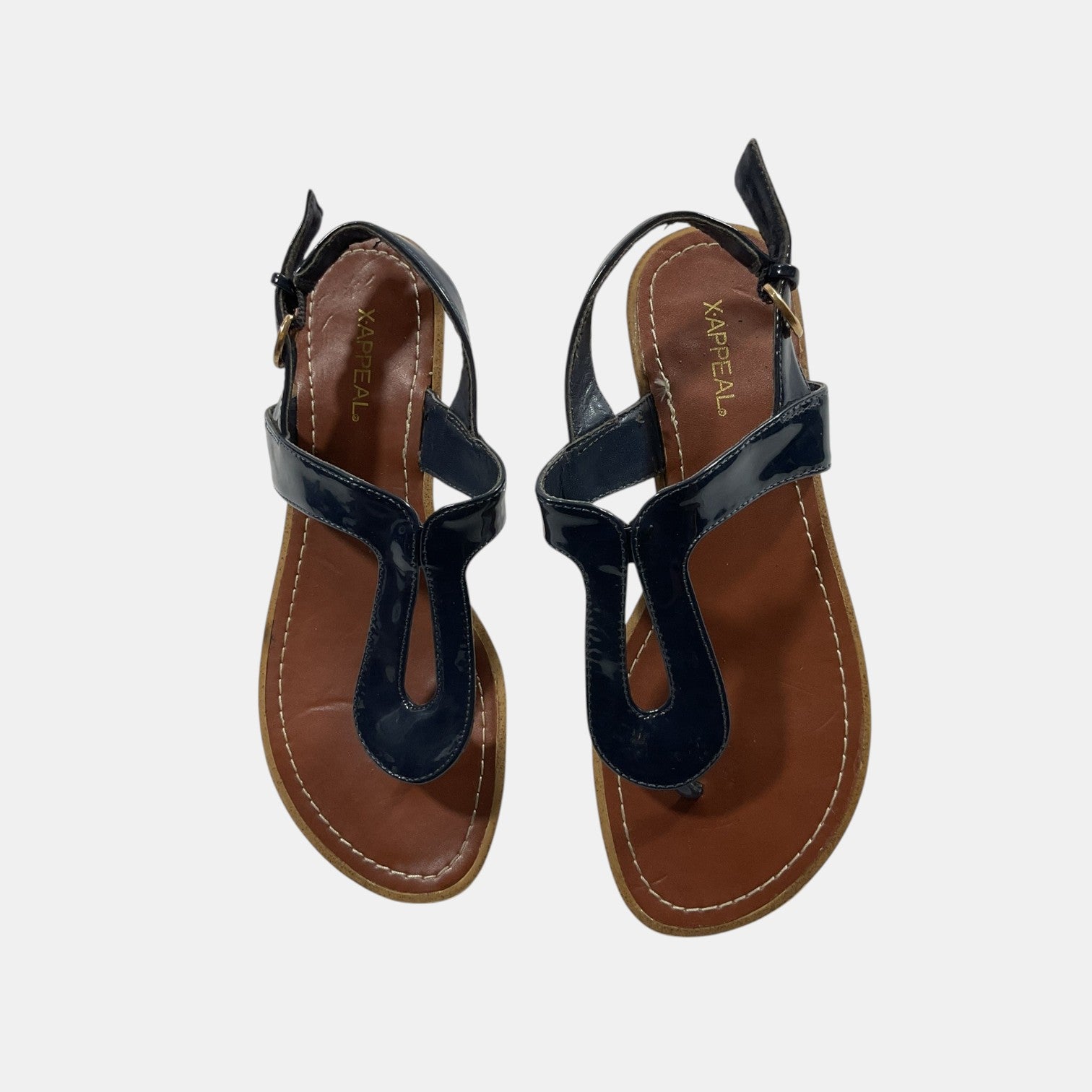 Pair of black sandals with brown soles on a light gray background
