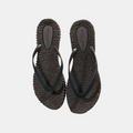 Pair of black woven sandals on a light gray background
