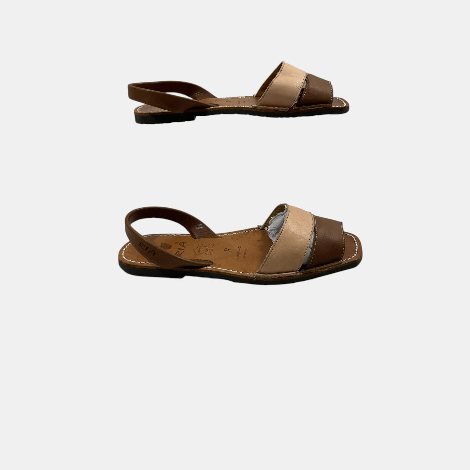 Pair of brown sandals with beige straps on a white background