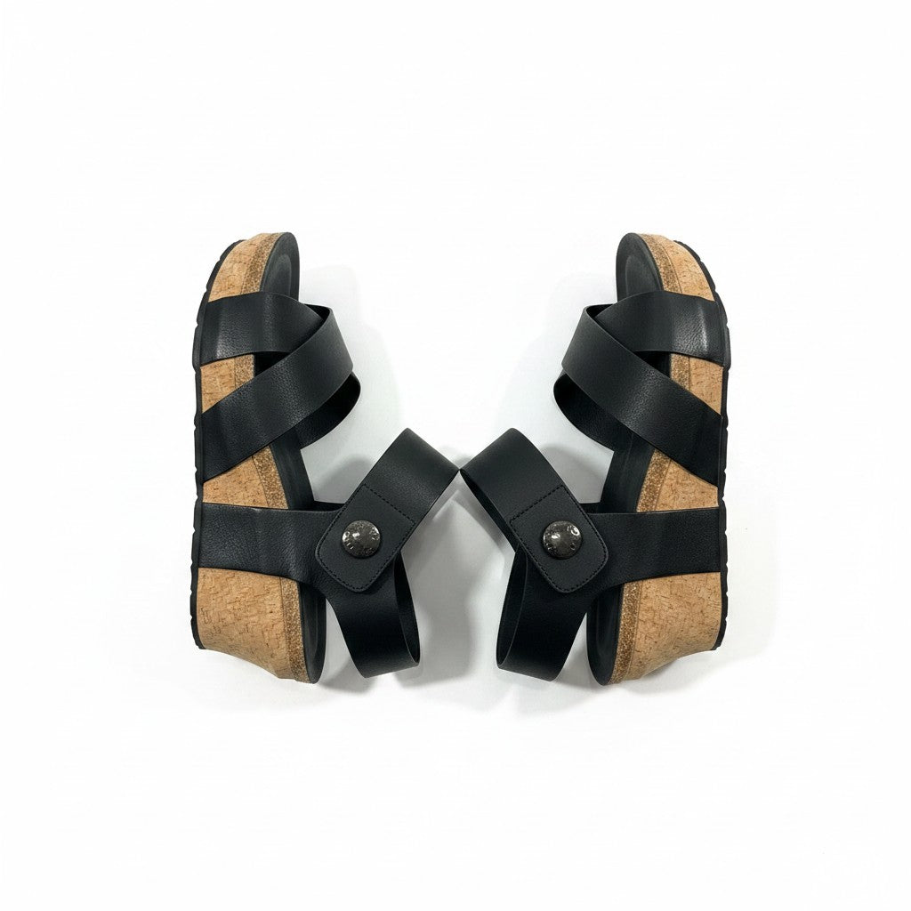 Pair of black strappy sandals with cork sole on a white background