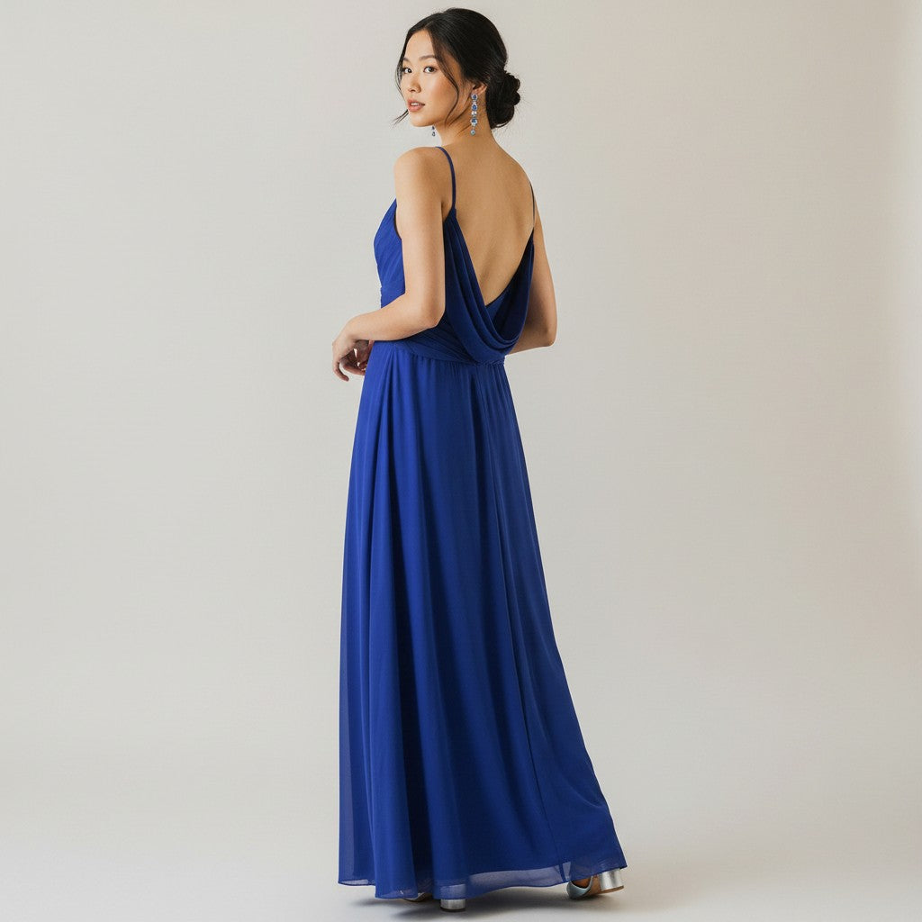 Woman wearing a blue evening gown with a plain background