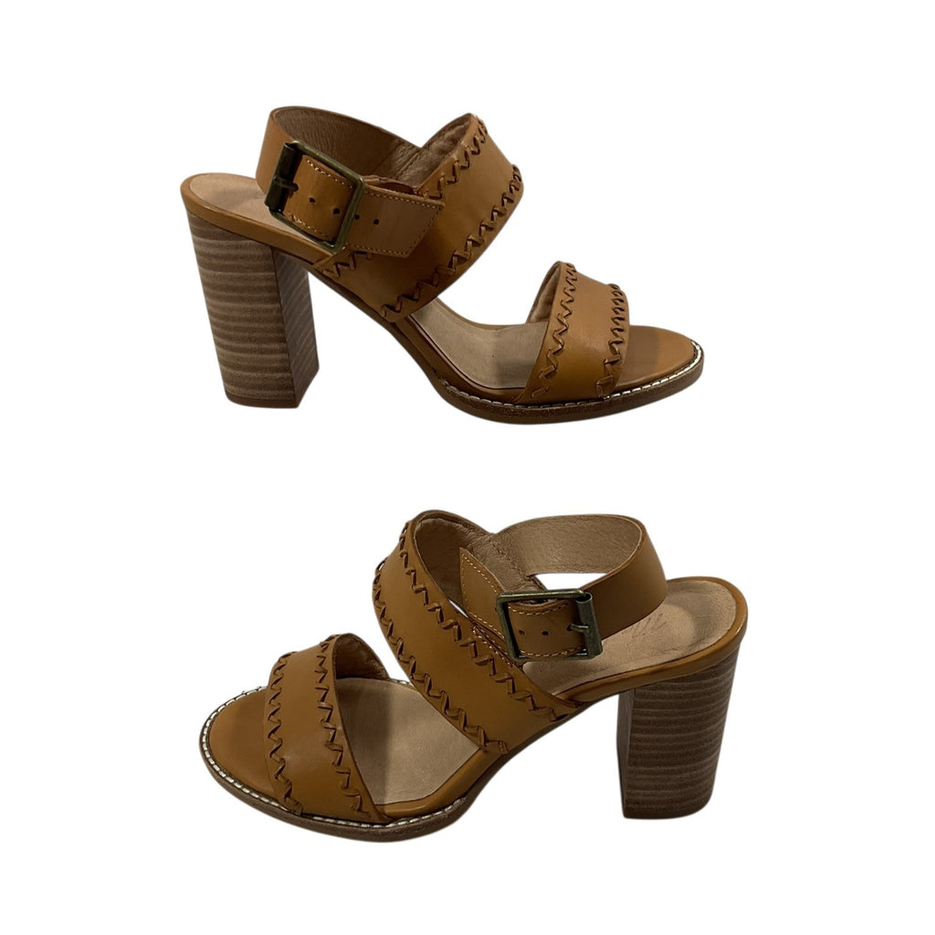 Pair of brown sandals with block heels on a white background