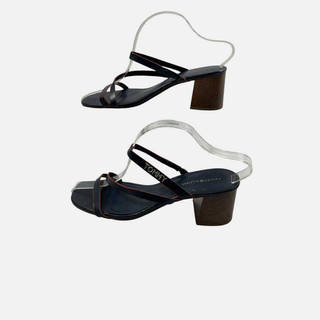 Black high-heeled sandals with transparent straps on a light gray background