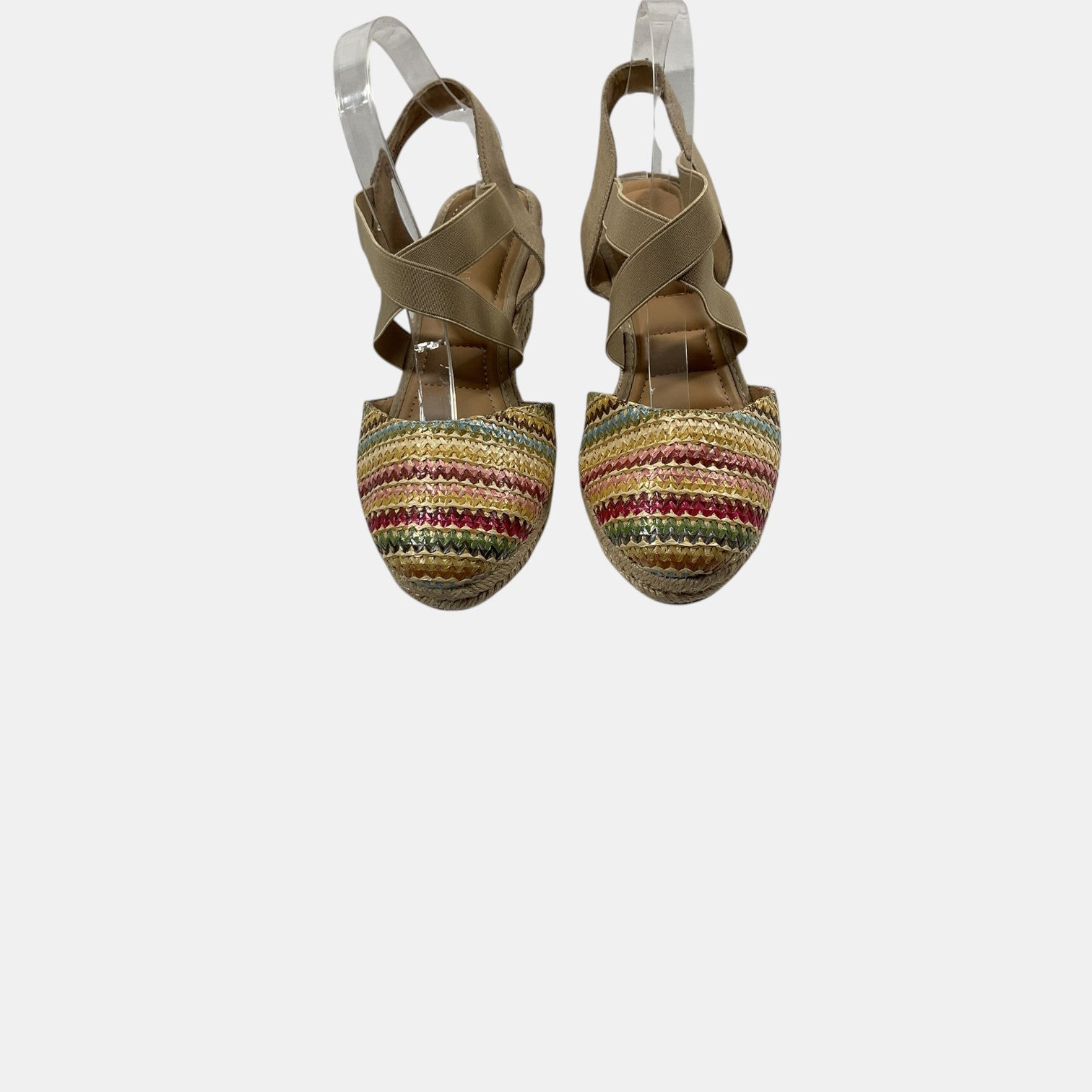 Pair of strappy sandals with colorful striped soles on a white background