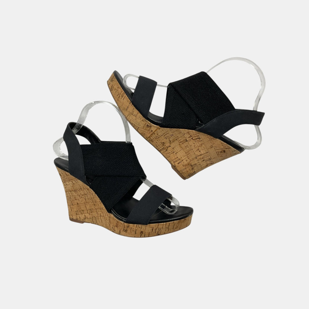 Black wedge sandals with cork platforms on a white background