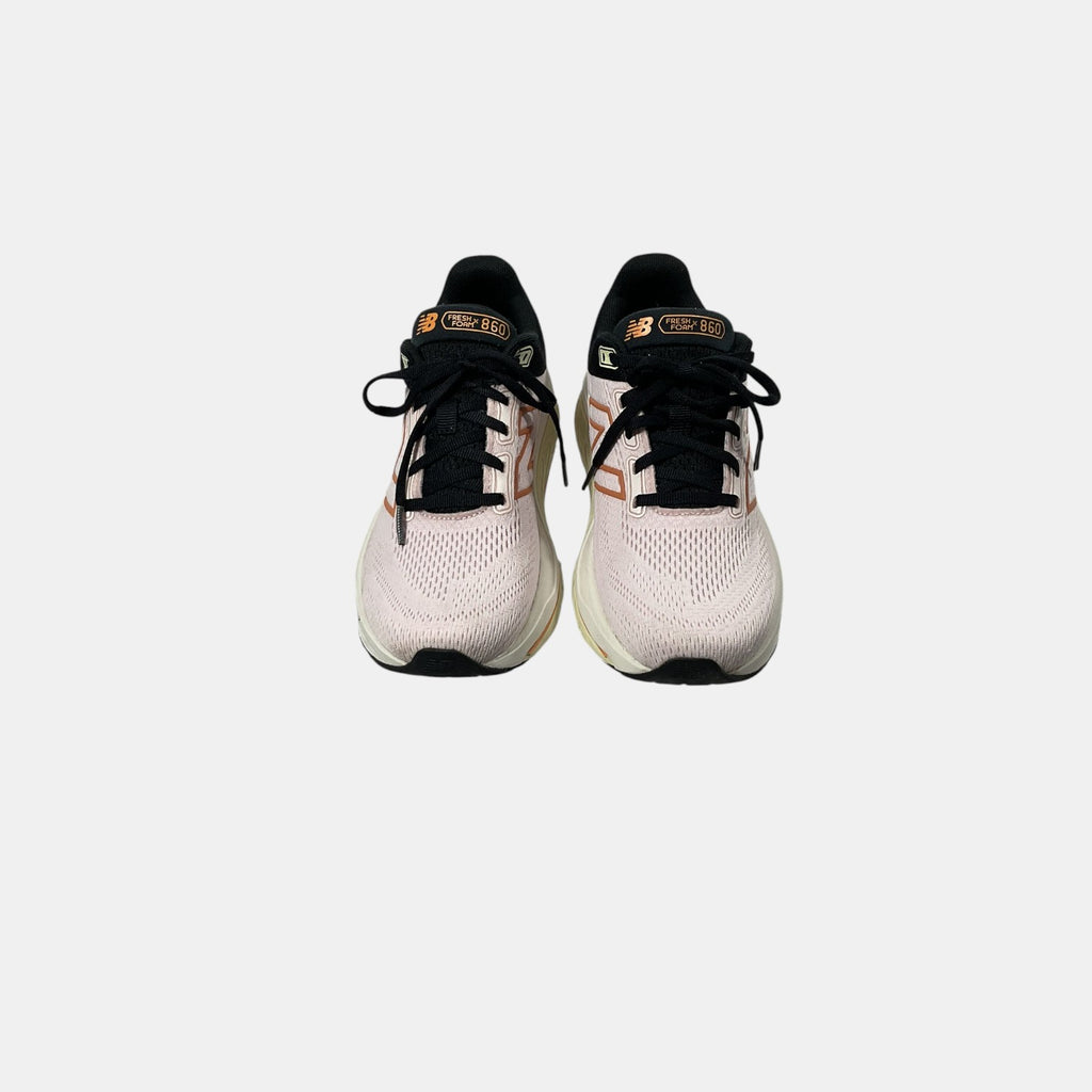 pink and black New Balance sneakers on a white background
