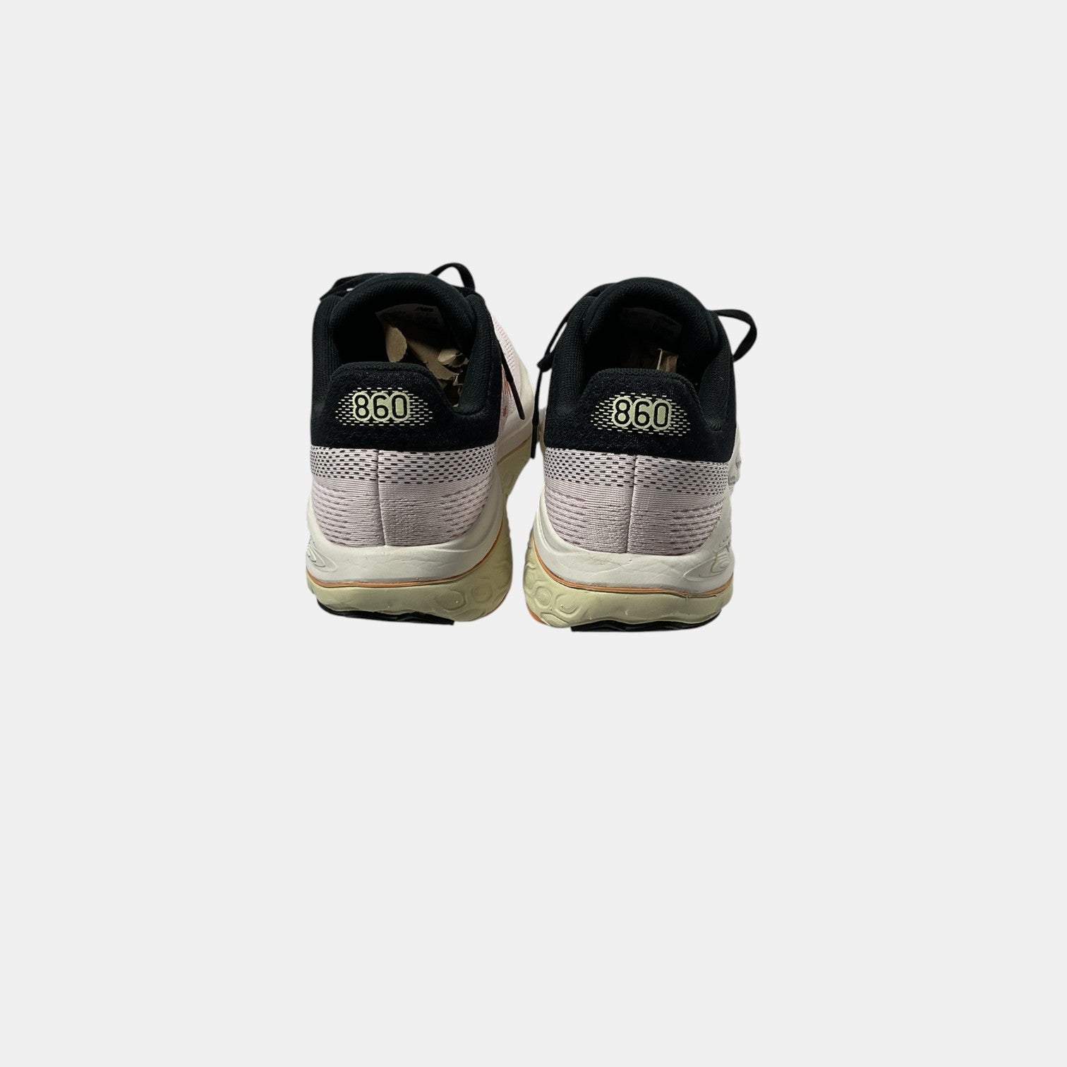 pink and black New Balance sneakers on a white background