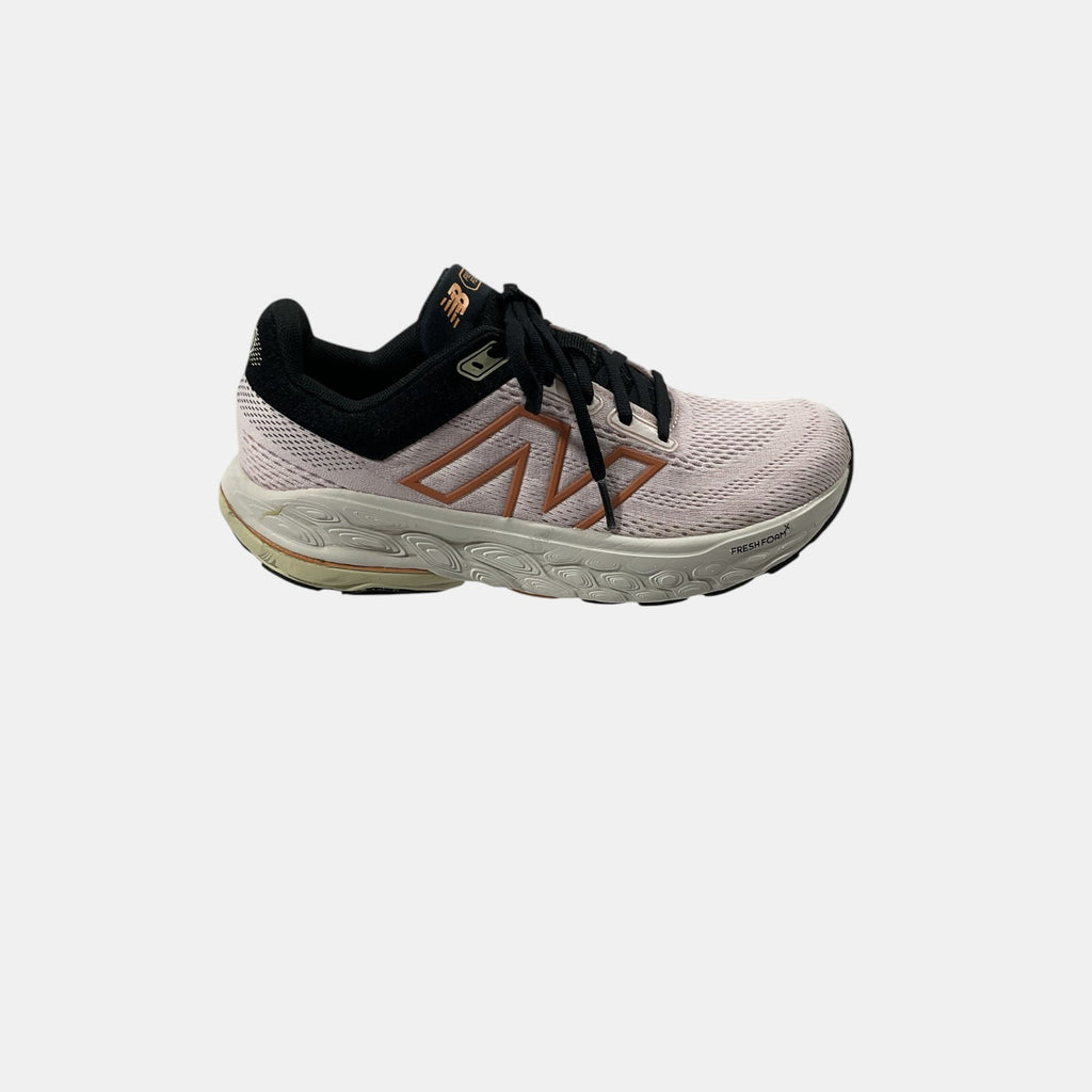 pink and black New Balance sneakers on a white background
