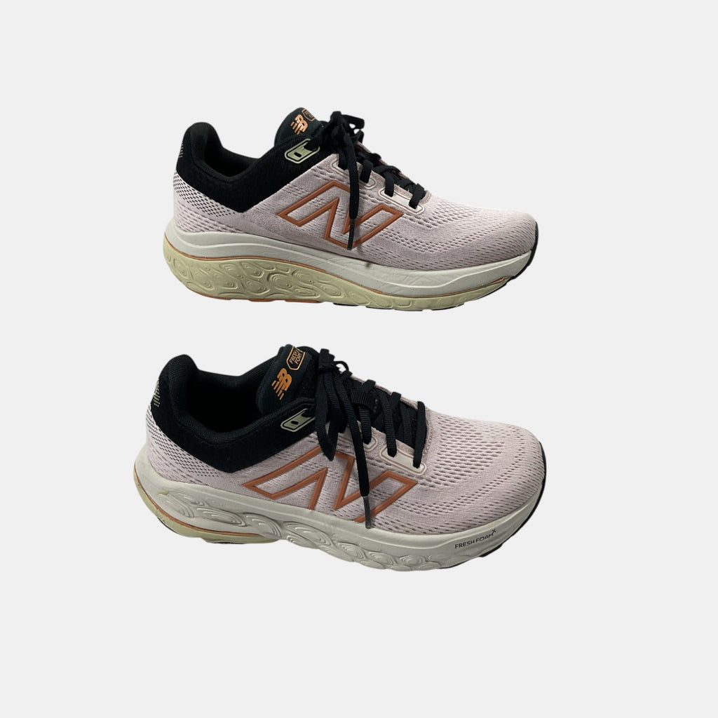 pink and black New Balance sneakers on a white background