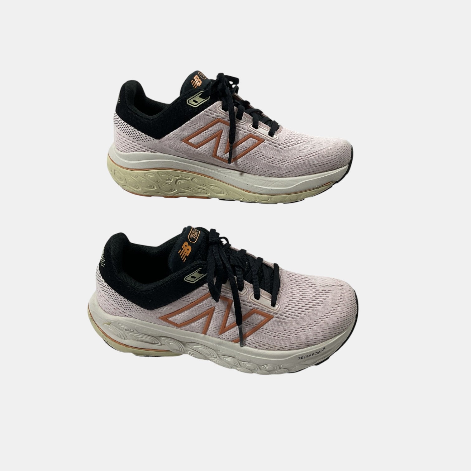 pink and black New Balance sneakers on a white background
