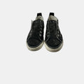 Black slip-on sneakers with rhinestone embellishments on a white background