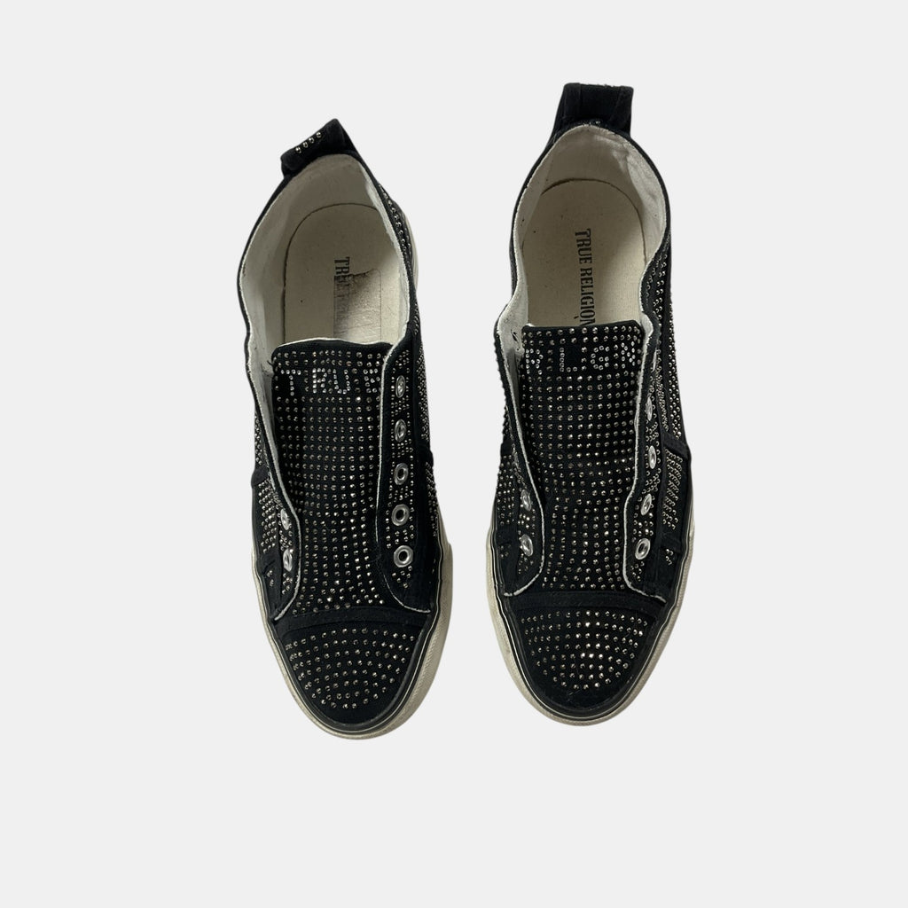 Black studded sneakers on a white background