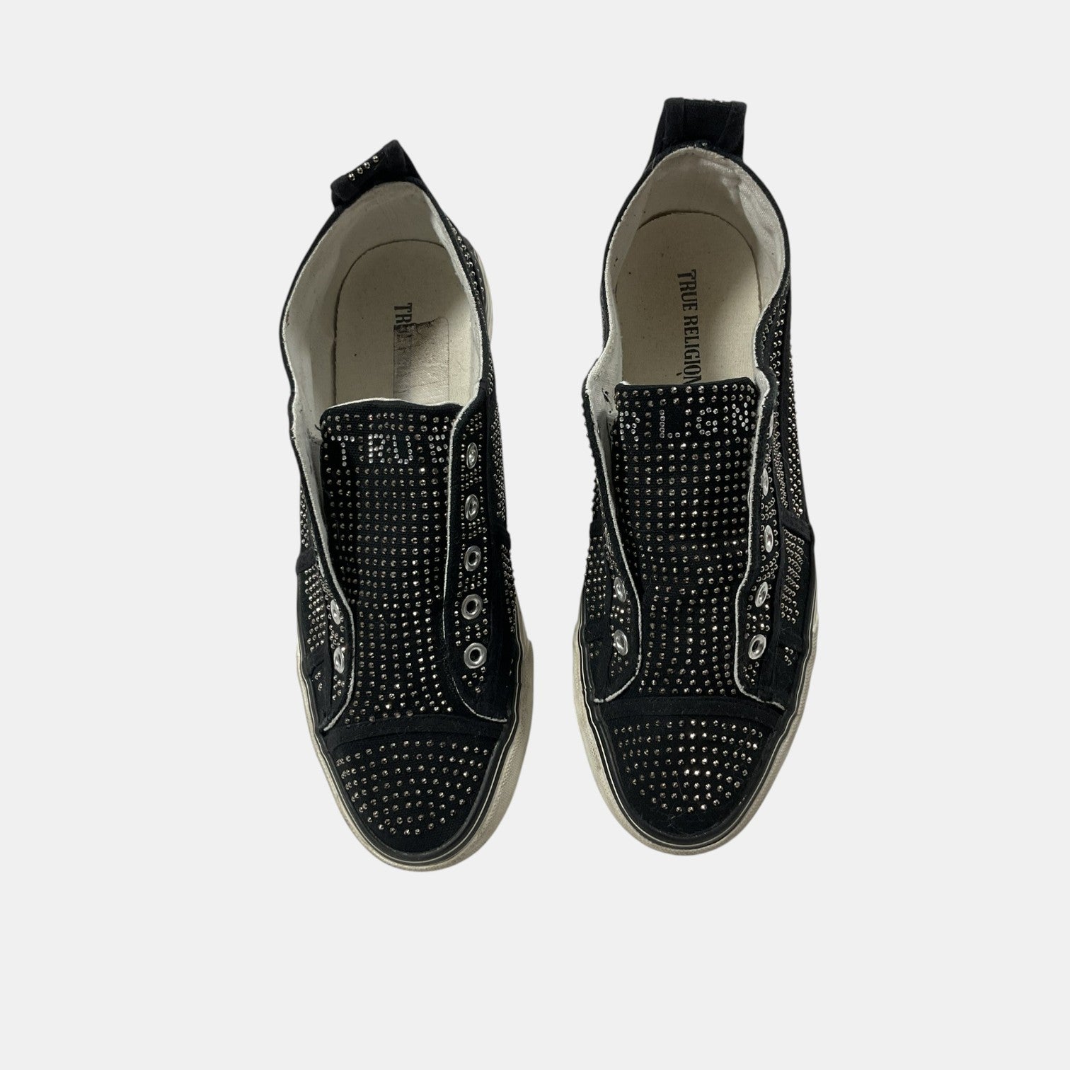 Black studded sneakers on a white background