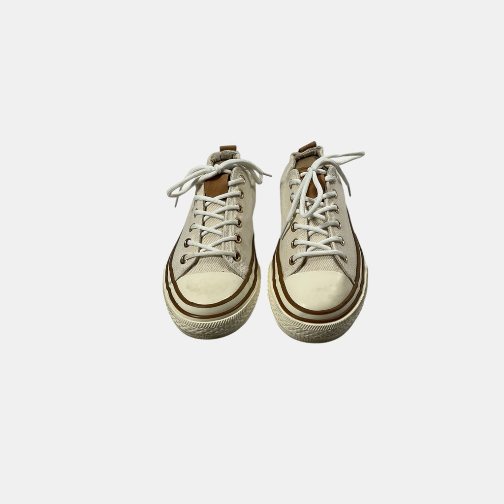 Pair of beige high-top sneakers on a light gray background