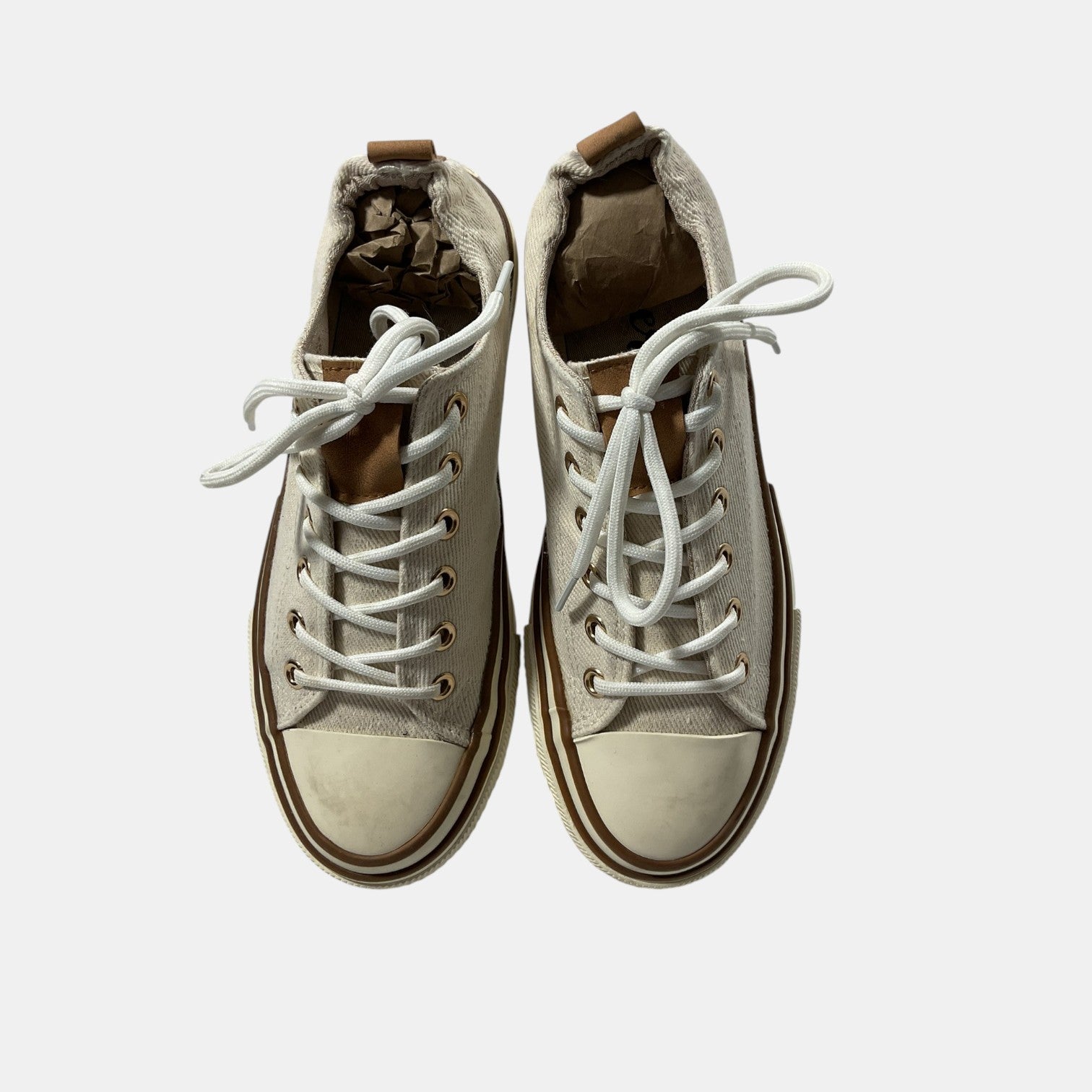 Pair of beige high-top sneakers with white laces on a light gray background