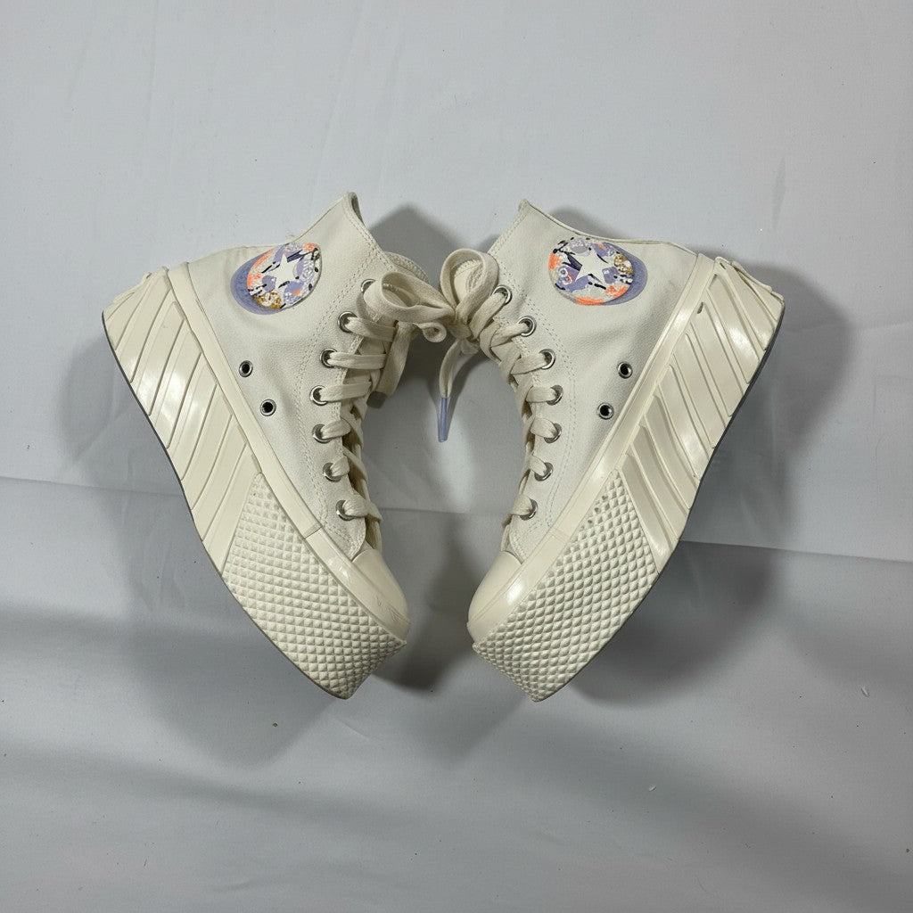 Pair of beige high-top sneakers with colorful circular designs on a light gray background