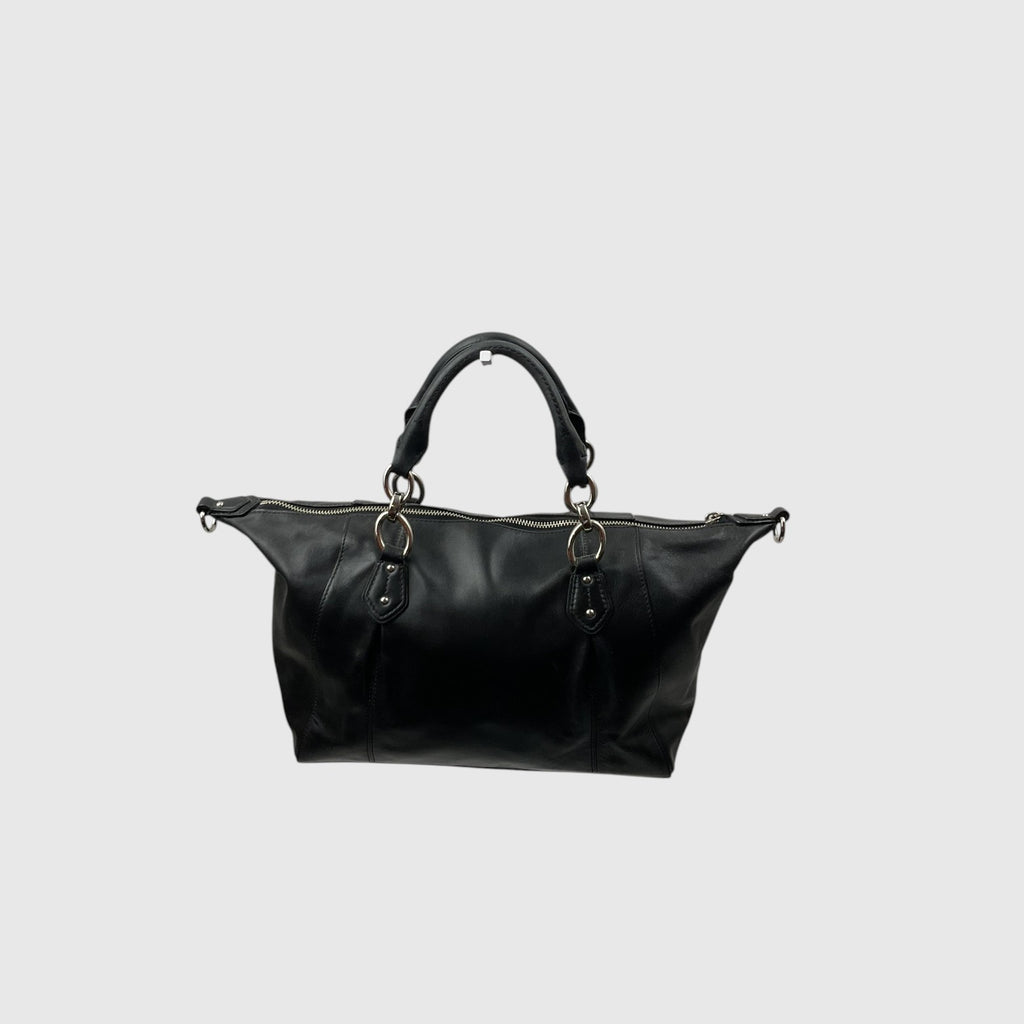 A black leather shoulder bag with dual top handles and gold-tone hardware, shown against a solid light gray background.