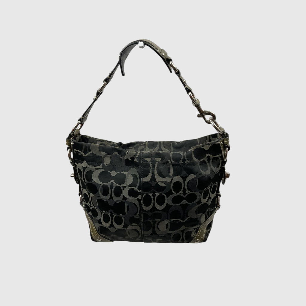A Coach hobo shoulder bag in black coated canvas with the signature interlocking C logo pattern in dark gray and black, featuring a matching shoulder strap with chain details, shown against a light gray background.