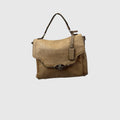 A tan textured leather handbag with a top handle, a front flap, and a silver-tone oval logo clasp, shown against a light gray background.