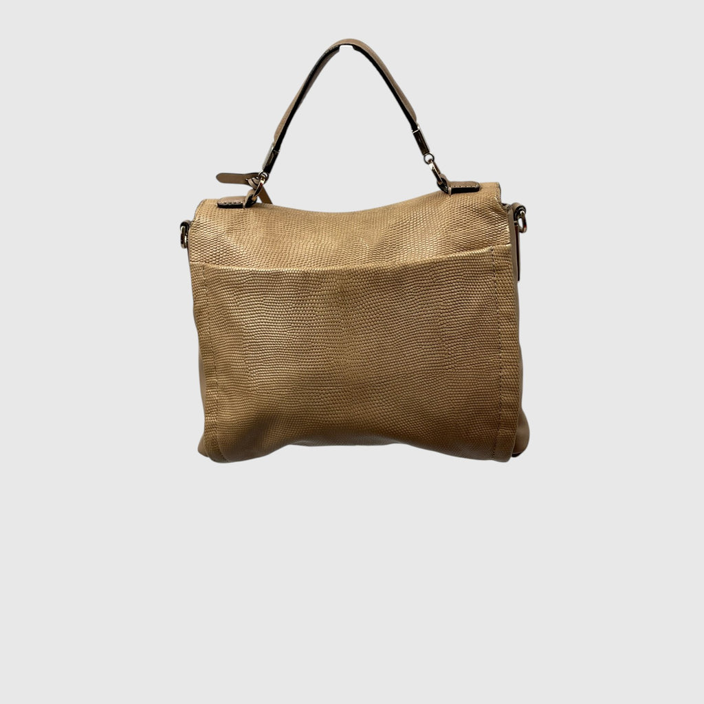 A tan textured leather handbag with a top handle and a front pocket, shown against a plain light gray background.
