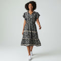 Woman wearing a black floral dress on a white background