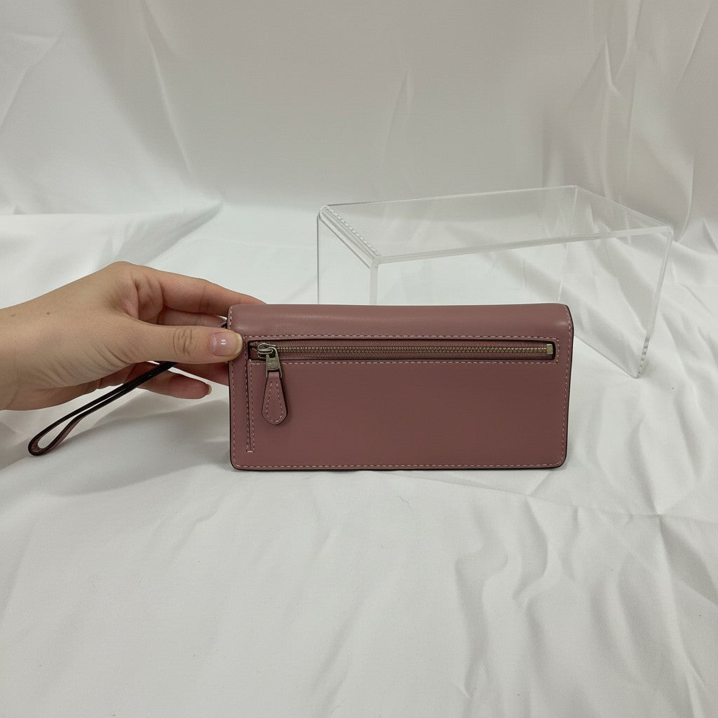 Pink wallet held by a hand on a white background