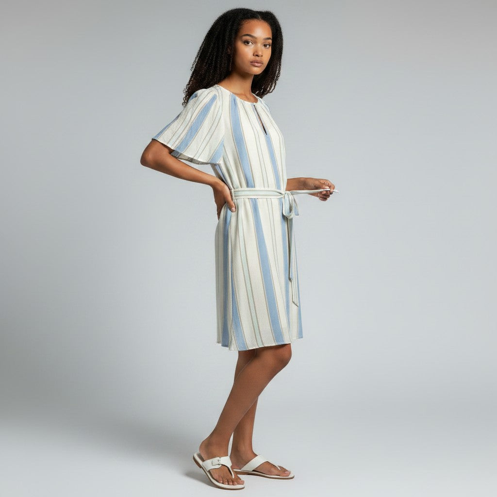 Woman wearing a striped dress on a gray background
