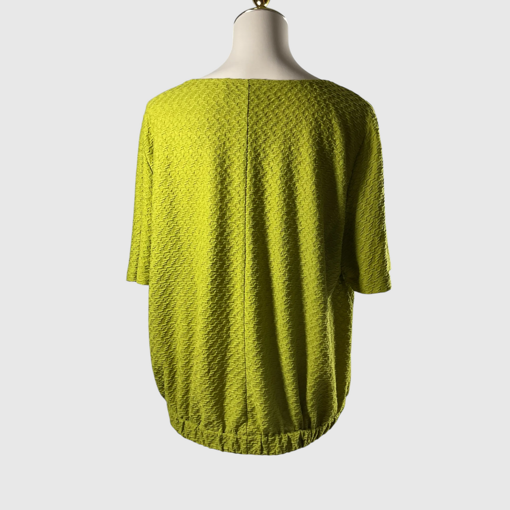 A textured lime green short-sleeve top displayed on a mannequin from the back, set against a plain light gray background.