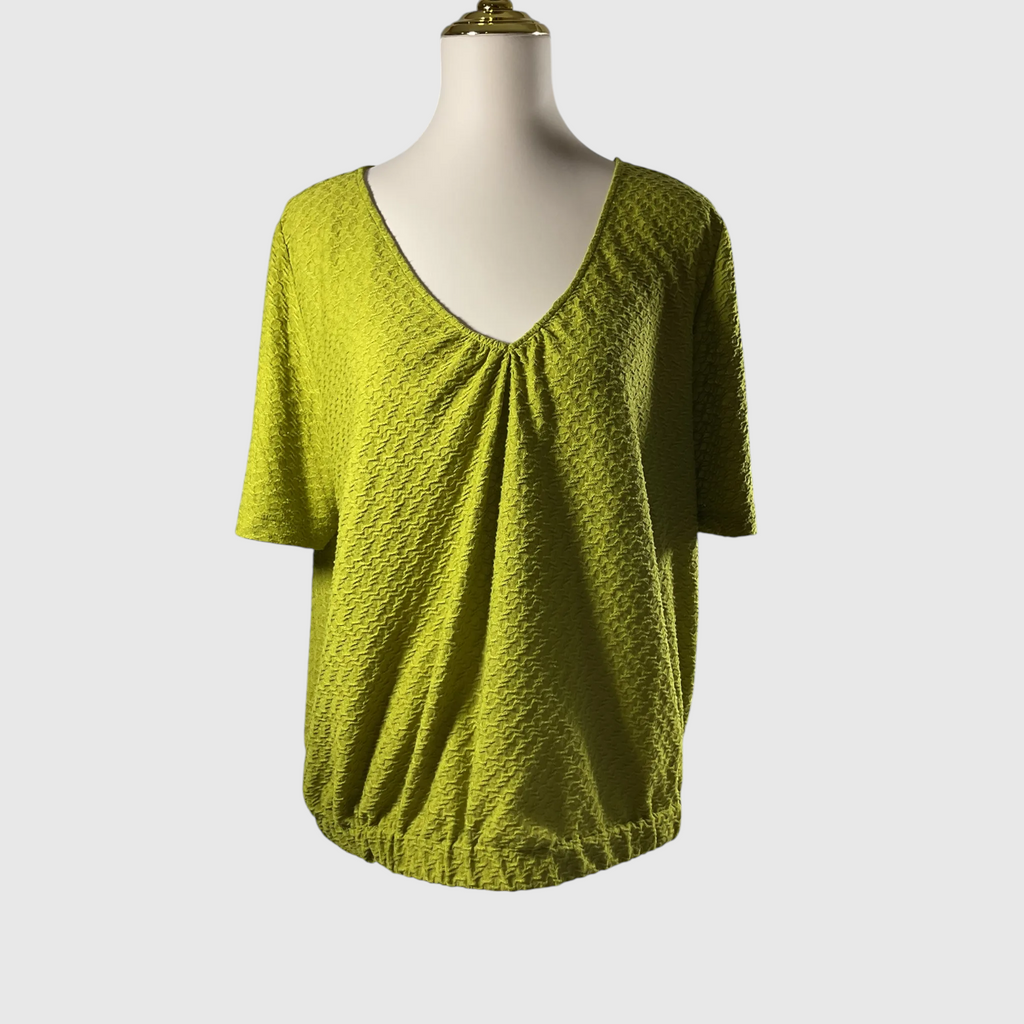 A textured olive green short-sleeve top with a V-neckline and gathered front detail, displayed on a mannequin torso against a light gray background.